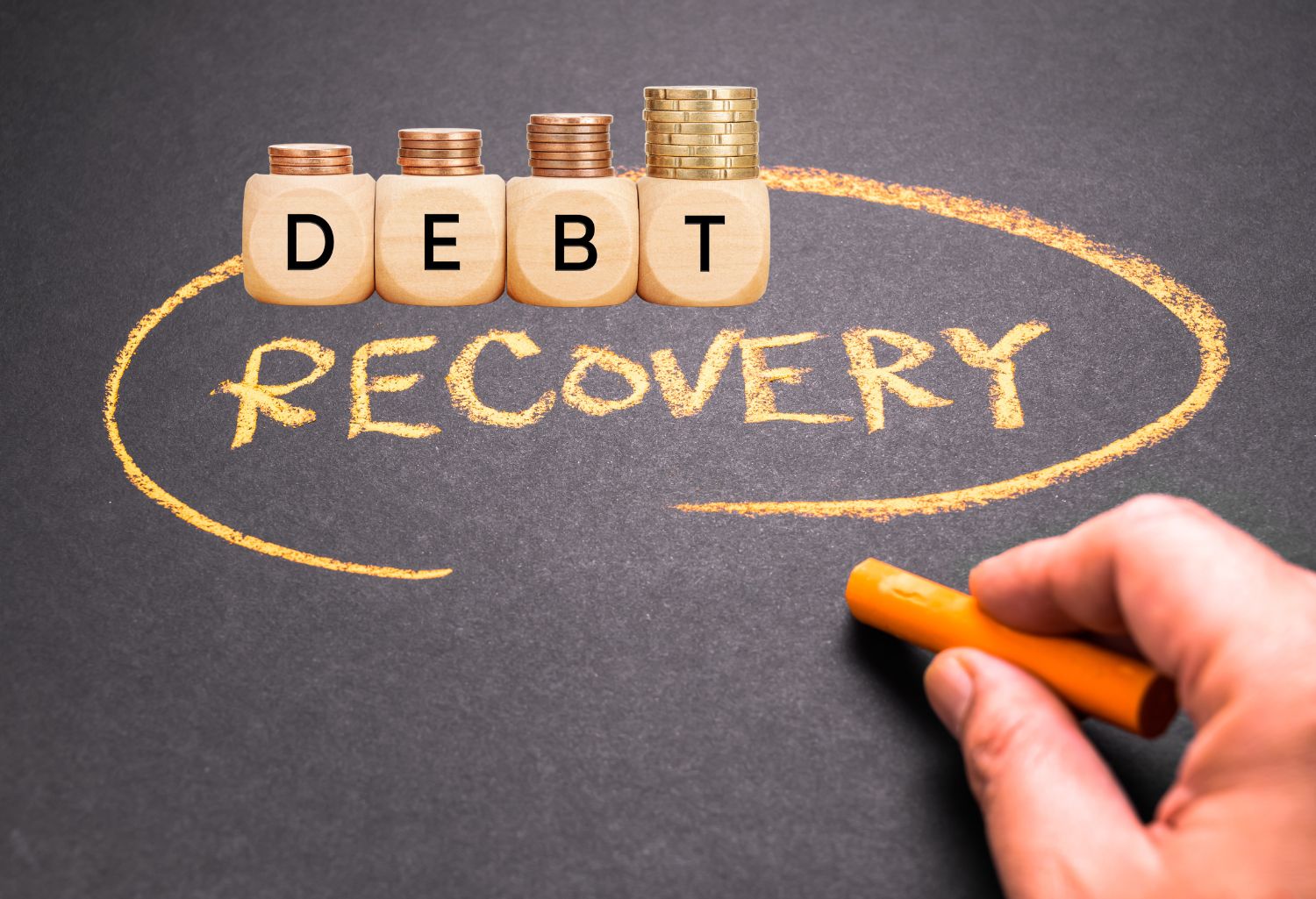 Closeup hand write a RECOVERY word topic on a chalkboard, wooden blocks with text and coins on wooden table representing tailored debt recovery.